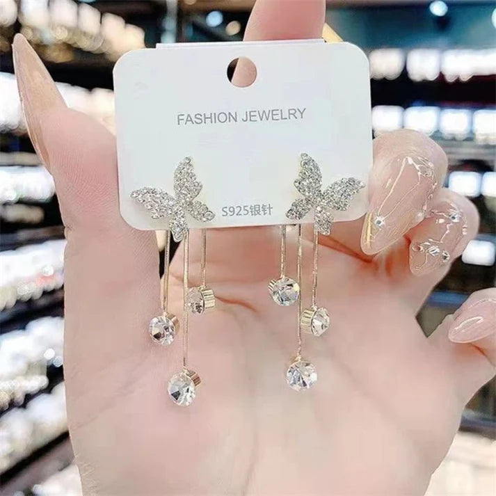 Shiny butterfly rhinestone earrings with pearl tassel, elegant, long dangle.